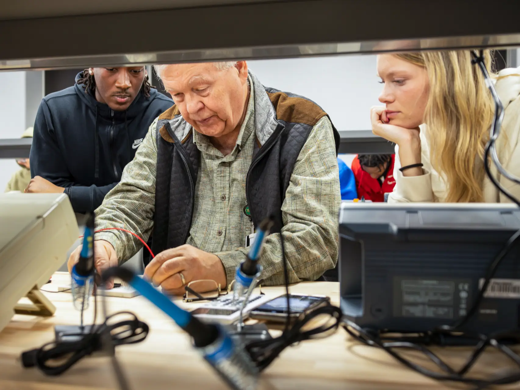 Computer Science student learning how to solder form professor.
