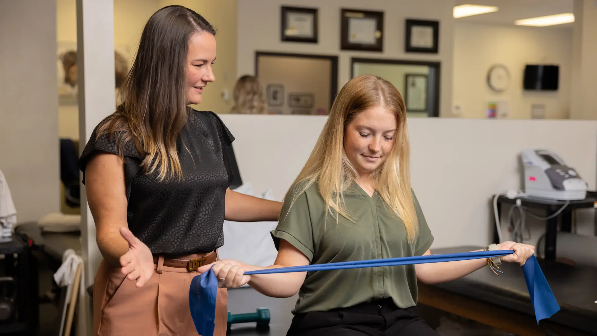 Dr. Bailey, left, is working with a patient to improve strength through variable resistance training.